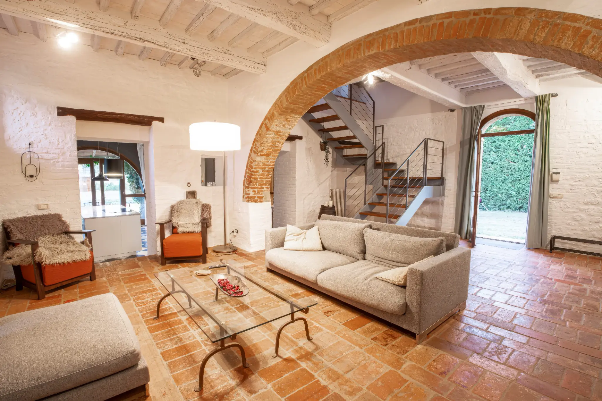 Living con archi, cotto e scala a vista